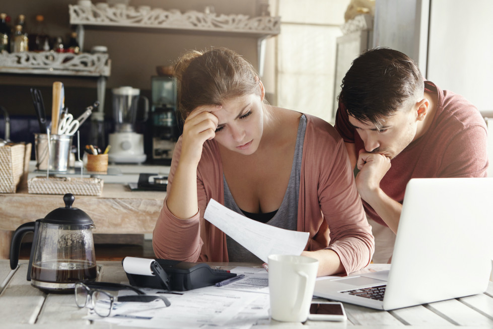 Matrimonio joven que enfrenta problemas financieros crisis economica mujer frustrada hombre infeliz estudiando factura servicios publicos