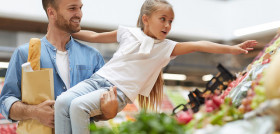 Little girl reaching fruit market